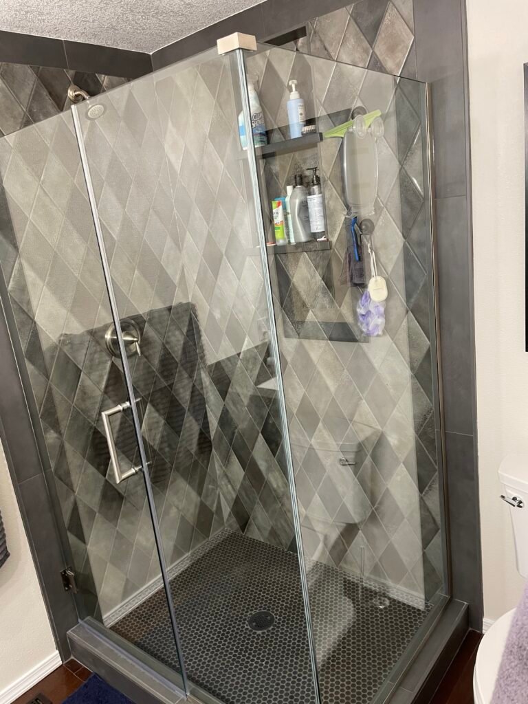 Custom bathroom remodel featuring a frameless glass walk-in shower, designer tile, recessed storage niche, and modern finishes completed by Barean Hilu LLC in Eastern Washington.