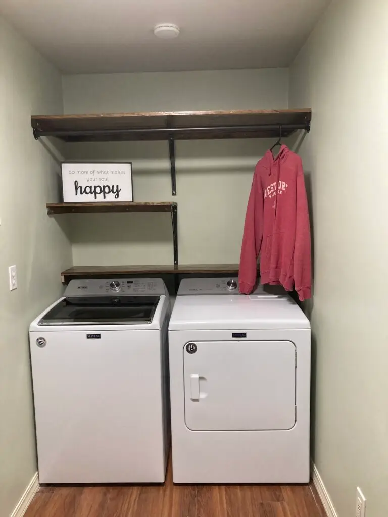 Remodeled laundry room featuring custom wood shelving, hanging storage, and modern finishes completed by Barean Hilu LLC in Pasco, Washington.